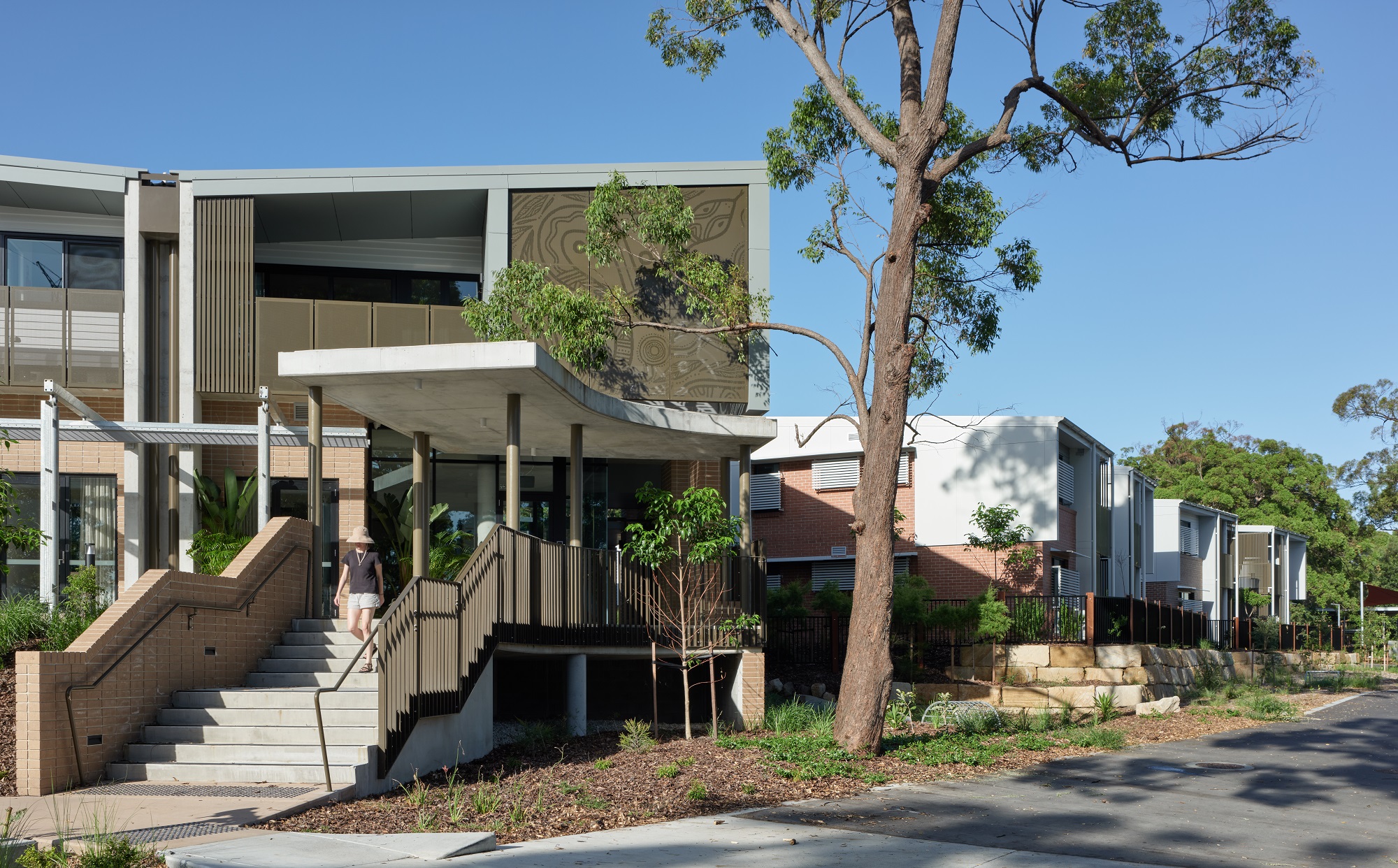 photo of building, front stairs, woman walking down to footpath