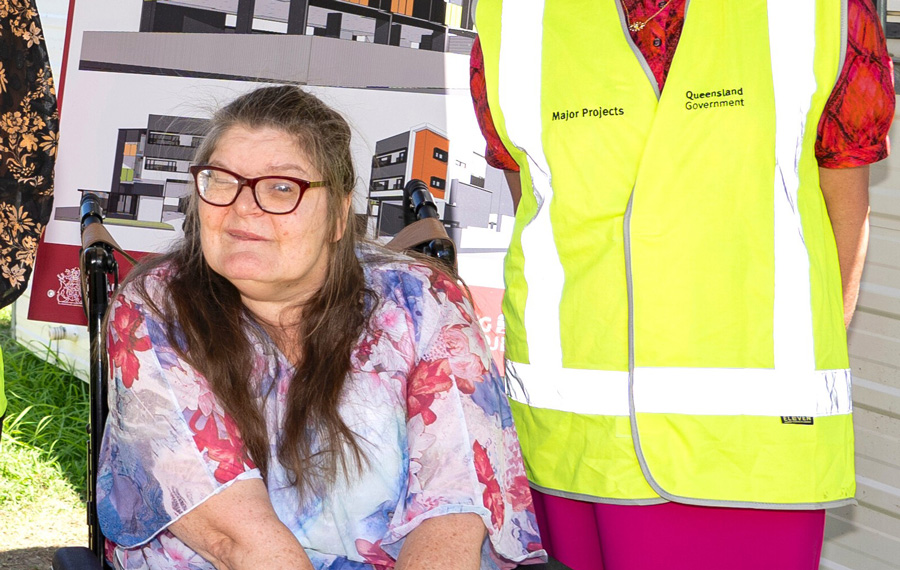 Deb in front of 3D renders of an accessible social housing complex